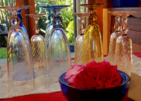 Coloured glassware with bowl of roses.