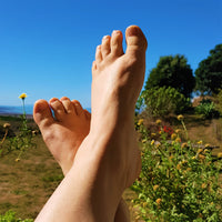 crossed feet against blue sky and garden